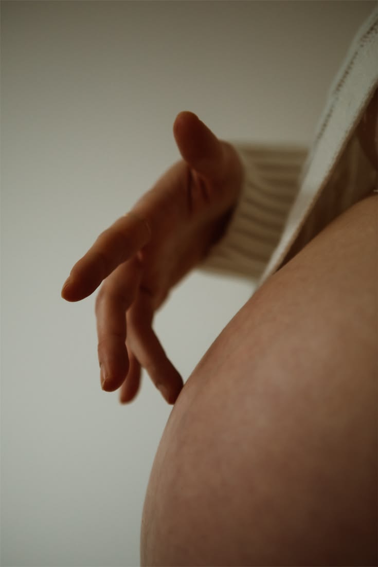 Detalhe de gestante com a mão sobre a barriga